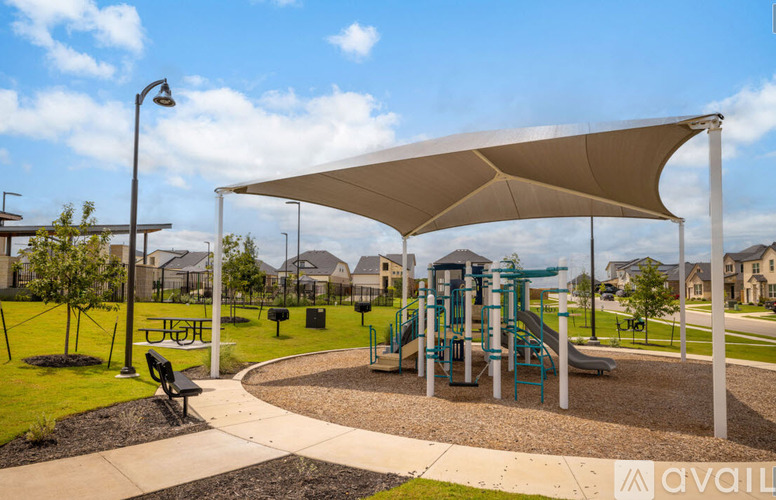 A playground with a slide and a shaded area.