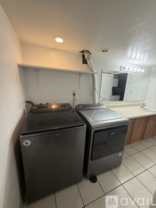 A black dishwasher and a black washing machine in a small kitchen.