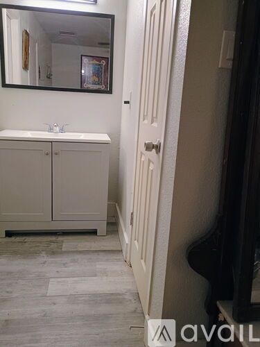 A bathroom with a white sink and a white cabinet.