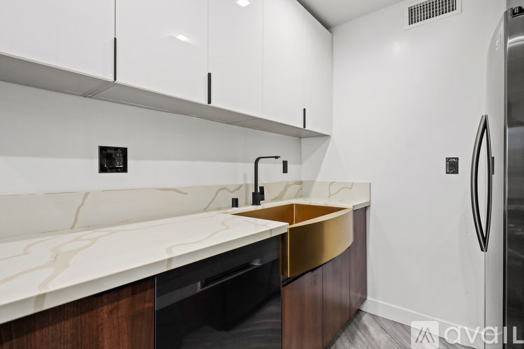 A kitchen with white cabinets and a marble countertop.