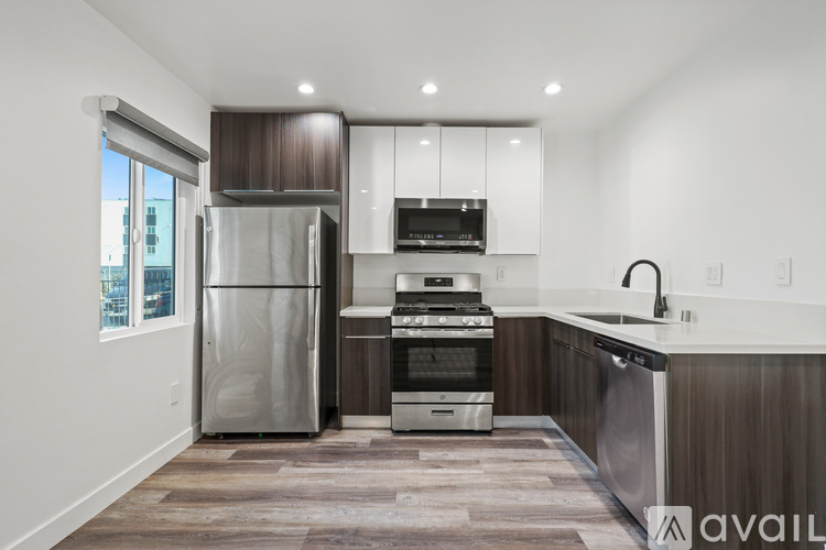 A modern kitchen with a stainless steel refrigerator, oven, and dishwasher.