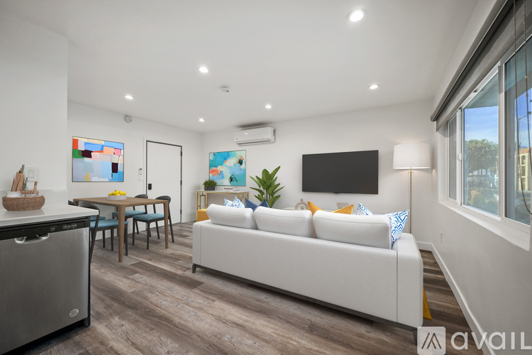 A modern living room with a white sofa and a wooden dining table.