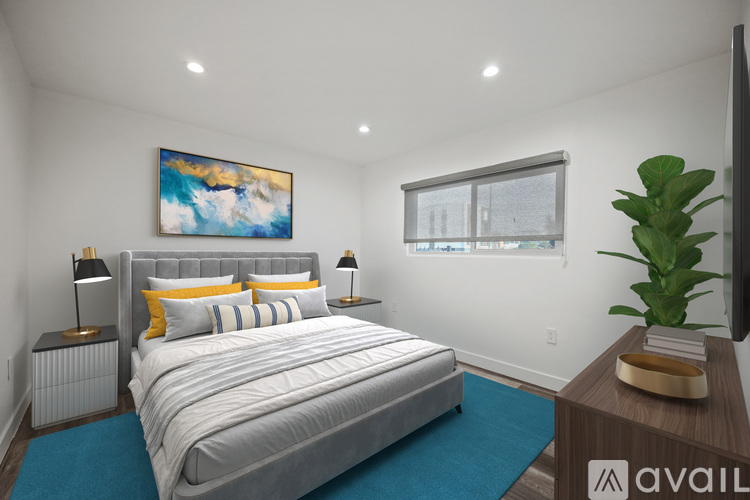 A bedroom with a large bed, a painting on the wall, and a television.