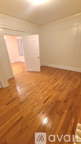 A room with wooden flooring and a white door.