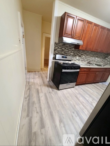 A kitchen with wooden cabinets and a black stove top oven.