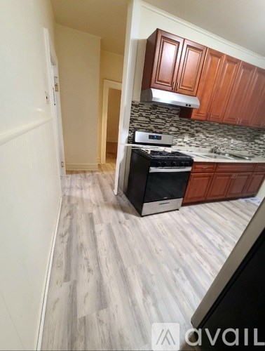 A kitchen with wooden cabinets and a black stove top oven.