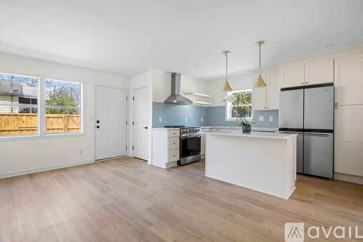 A kitchen with a white island and stainless steel appliances.