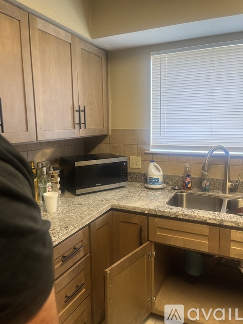A kitchen with wooden cabinets and a granite countertop.