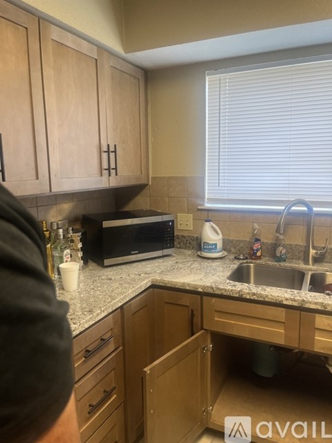 A kitchen with wooden cabinets and a granite countertop.