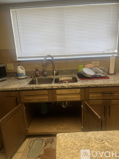 A kitchen with a granite countertop and wooden cabinets.