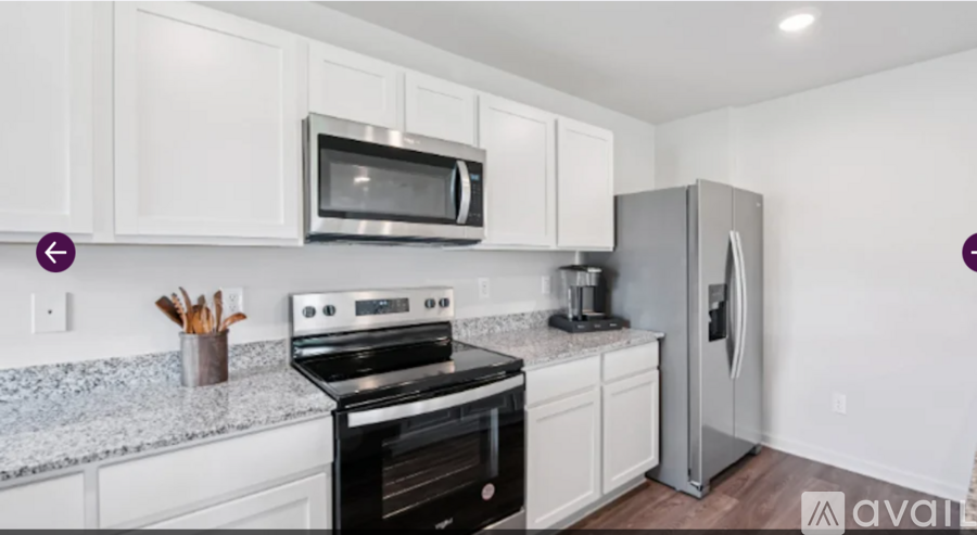 A kitchen with white cabinets and a black stove top oven.