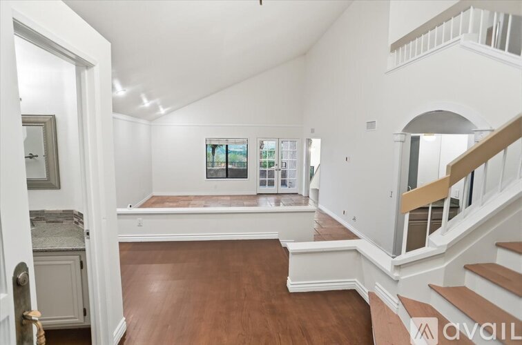 A spacious room with a staircase and a window.