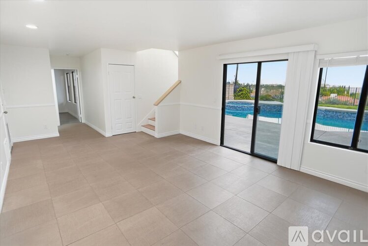 A spacious room with a pool visible through the sliding glass doors.