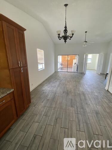 A room with wooden floors and a chandelier.