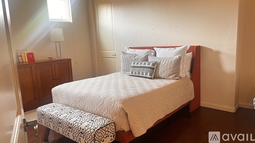 A bedroom with a large bed and a carpeted floor.