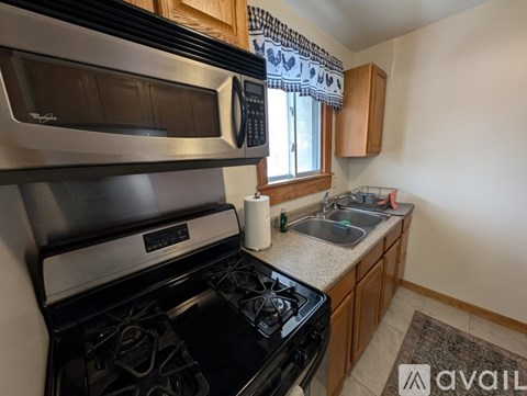 A kitchen with a stove, microwave, and sink.