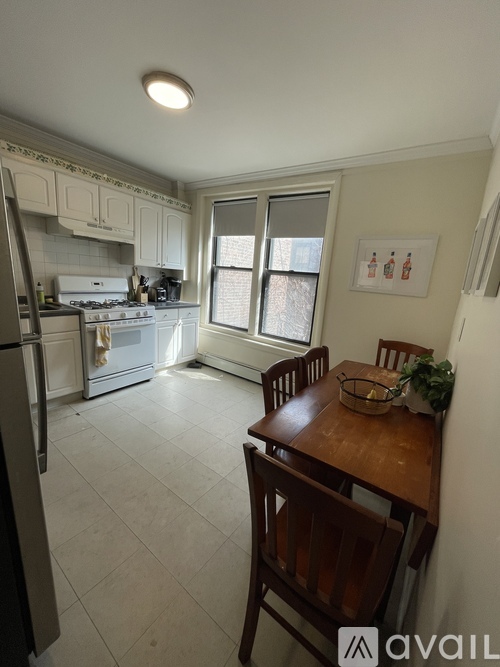 A kitchen with a refrigerator, stove, and table.