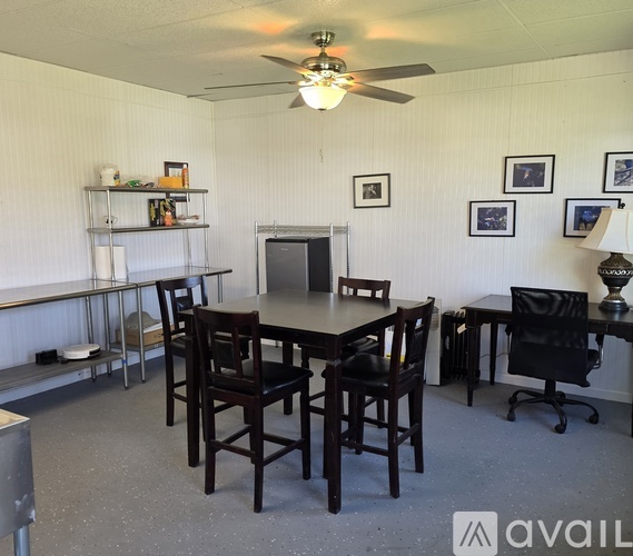A dining room with a table and chairs.
