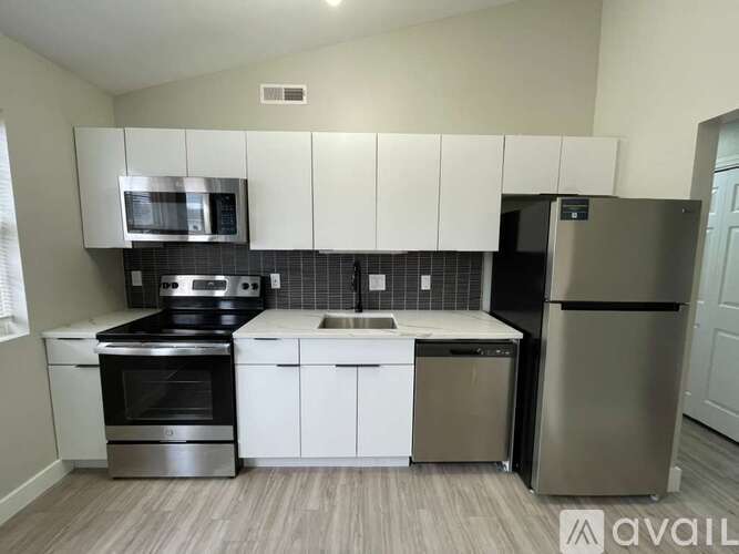 A kitchen with white cabinets and stainless steel appliances.