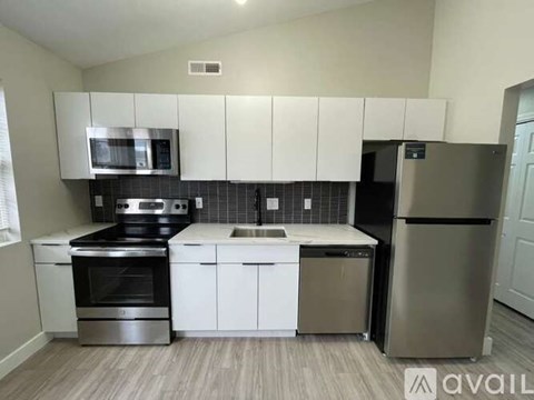 A kitchen with white cabinets and stainless steel appliances.
