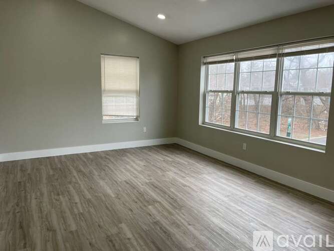 A room with a large window and wooden flooring.