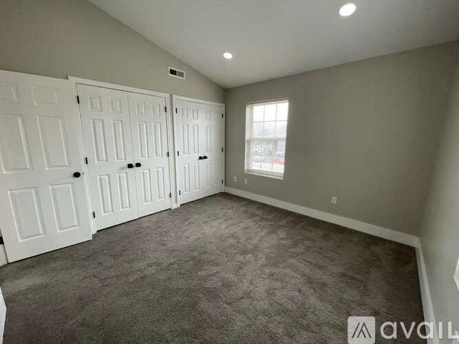 A room with white doors and a carpeted floor.