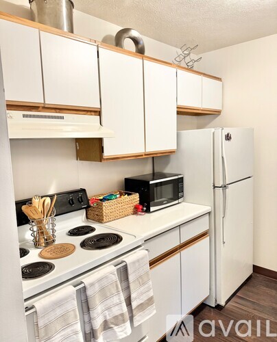 A kitchen with white cabinets and a white fridge.