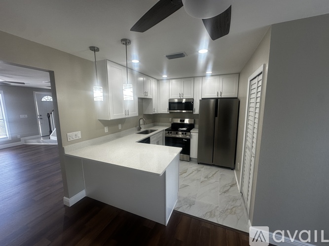 A modern kitchen with a white island and stainless steel appliances.