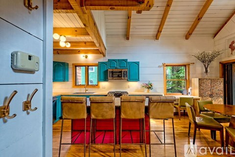 A dining room with a wooden table and chairs.