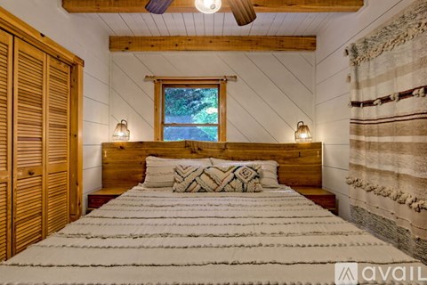 A bedroom with a large bed and wooden furniture.