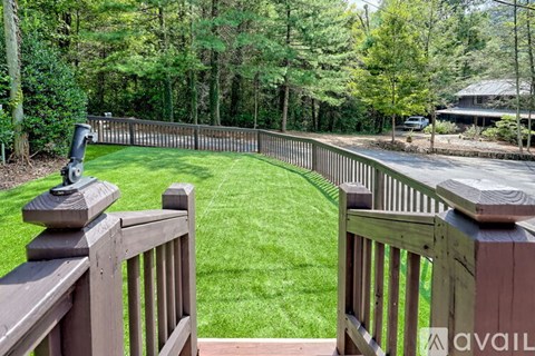 A backyard with a wooden fence and a grassy area.