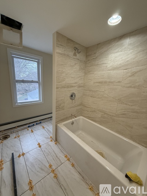 A bathroom with a tub, sink, and window.