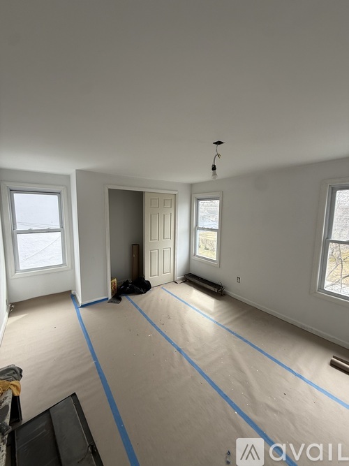 A room with a lot of white walls and a ceiling with a light fixture.