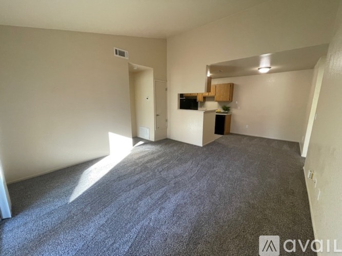 A room with a grey carpet and a white wall.