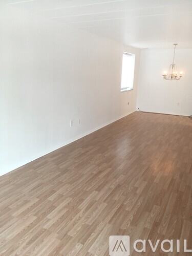 A room with wooden flooring and a chandelier.