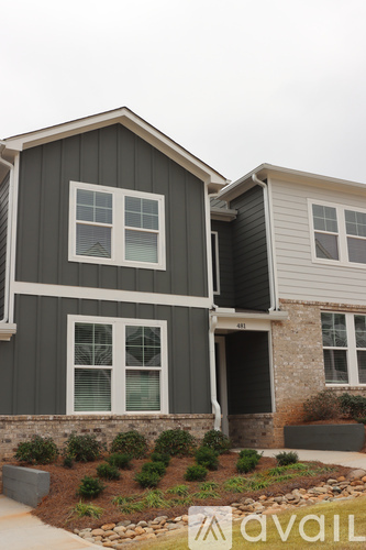 A grey house with a white door and windows.