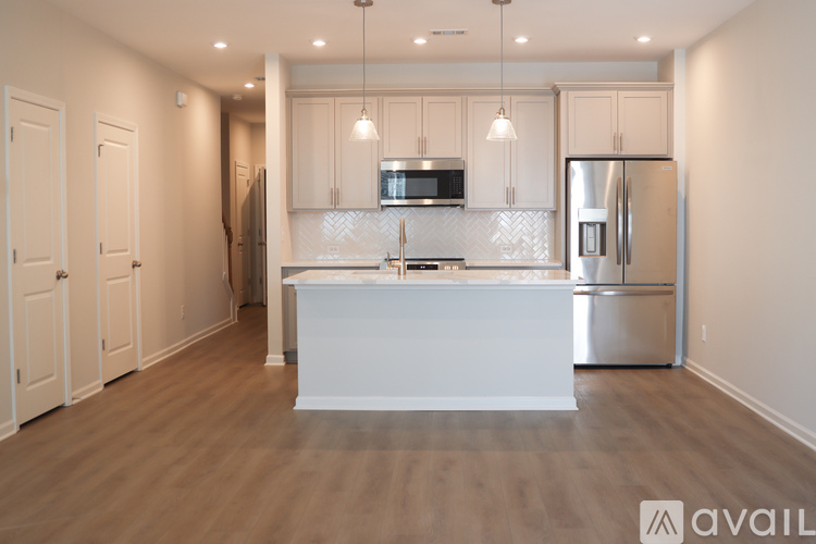 A kitchen with a white island and stainless steel appliances.