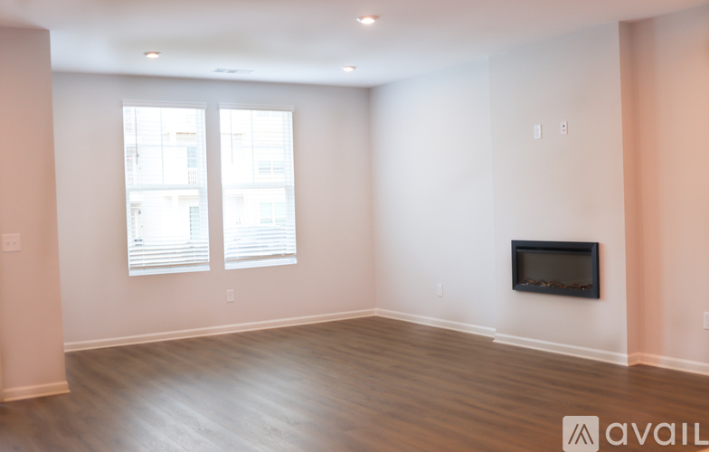 A spacious living room with a flat screen TV mounted on the wall.