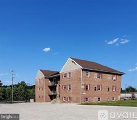 A large brick building with a parking lot in front.