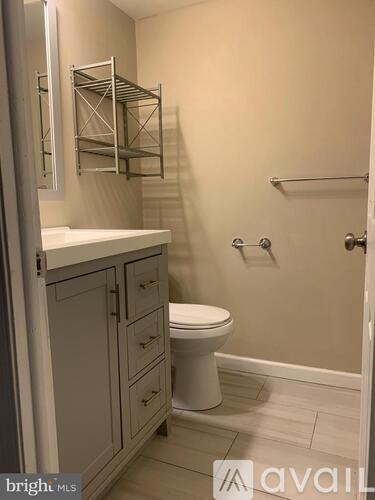 A white toilet sits in a bathroom with a cabinet and a mirror.