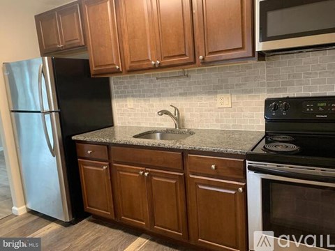 A kitchen with wooden cabinets and a black stove top oven.