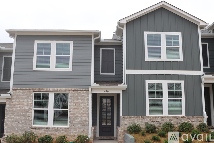 Two houses with grey siding and white windows are shown.
