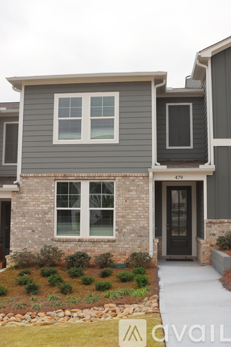 A grey house with a black door and windows.