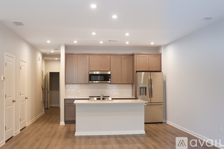 A kitchen with wooden cabinets and a white island.