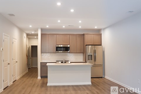 A kitchen with wooden cabinets and a white island.