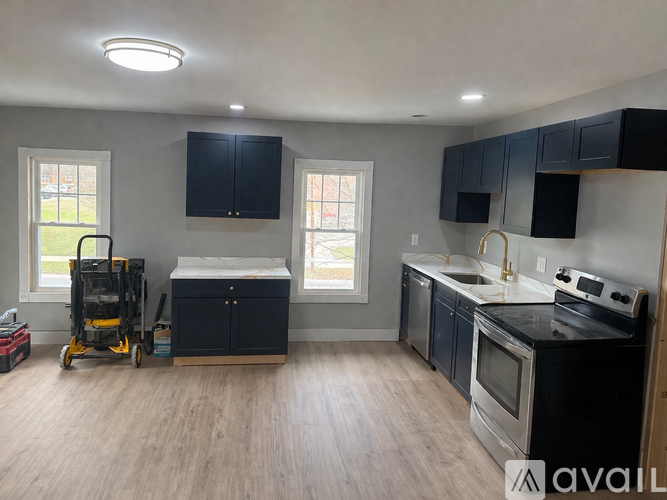 A kitchen with black cabinets and stainless steel appliances.