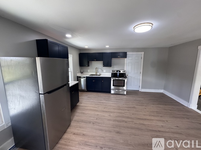 A kitchen with a refrigerator, oven, and sink.