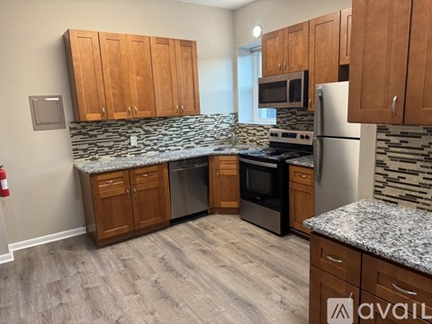 A kitchen with wooden cabinets and granite countertops.