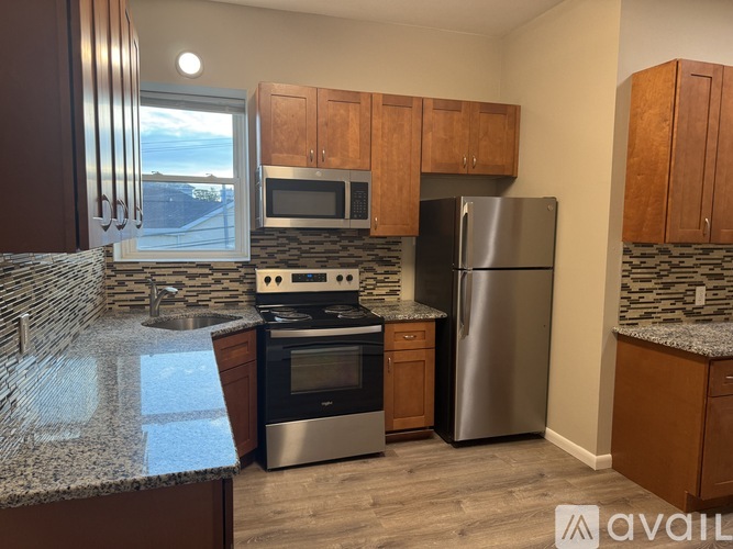 A kitchen with a granite counter top and stainless steel appliances.