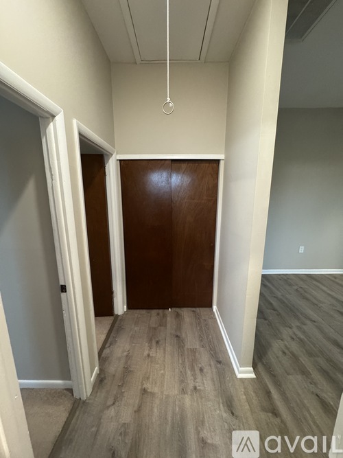 A room with a wooden door and a white door.